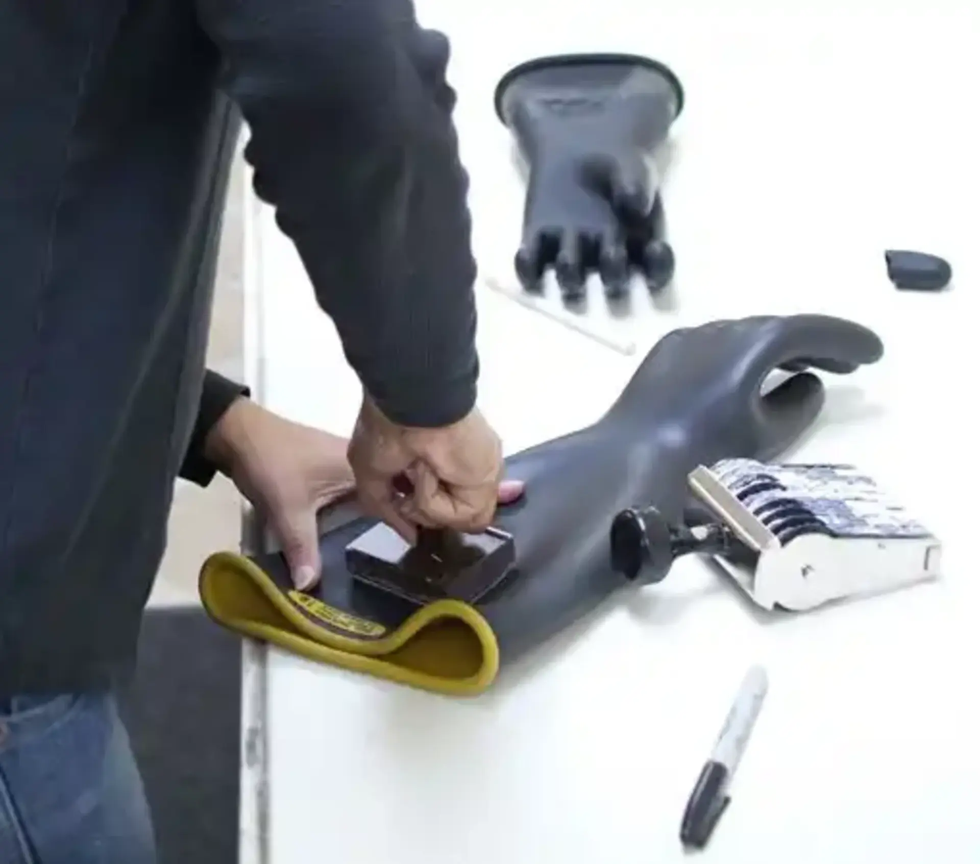Passing rubber gloves being stamped with voltage and test date per ASTM D120